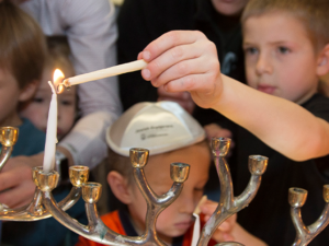 child lighting menorah