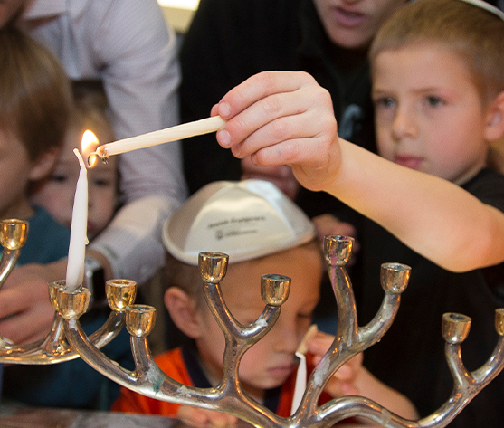 child lighting menorah